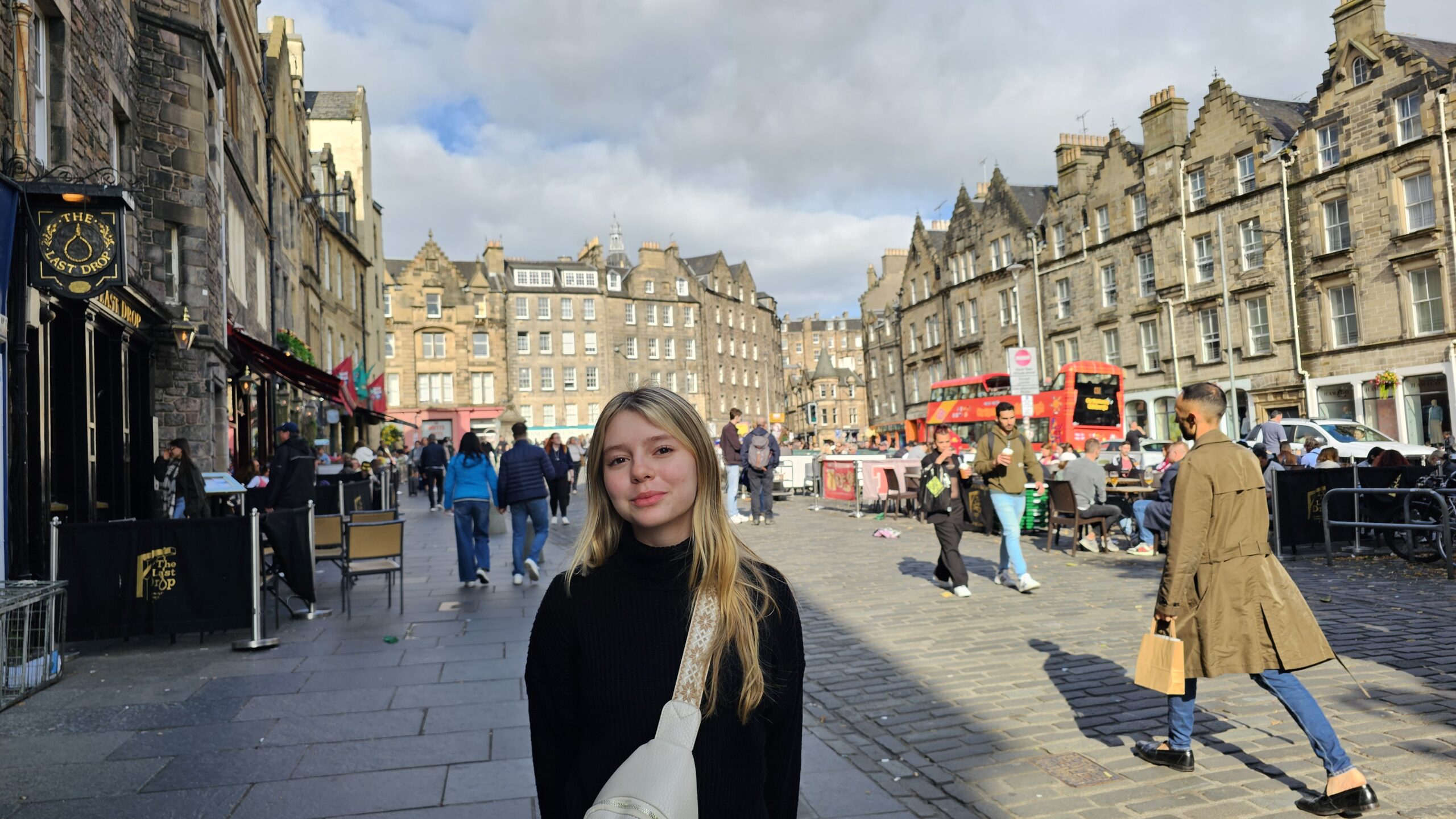 Praça Grassmarket em Edimburgo com o Castelo ao fundo e restaurantes históricos ao redor.