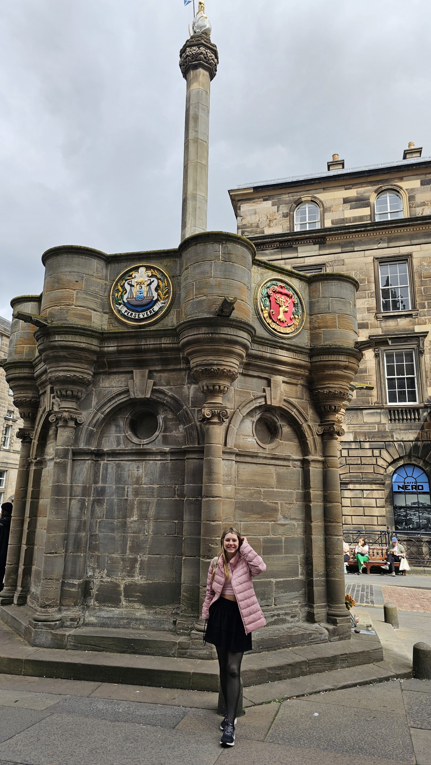 Monumento Mercat Cross em Edimburgo com coluna de pedra e unicórnio no topo, na Royal Mile.