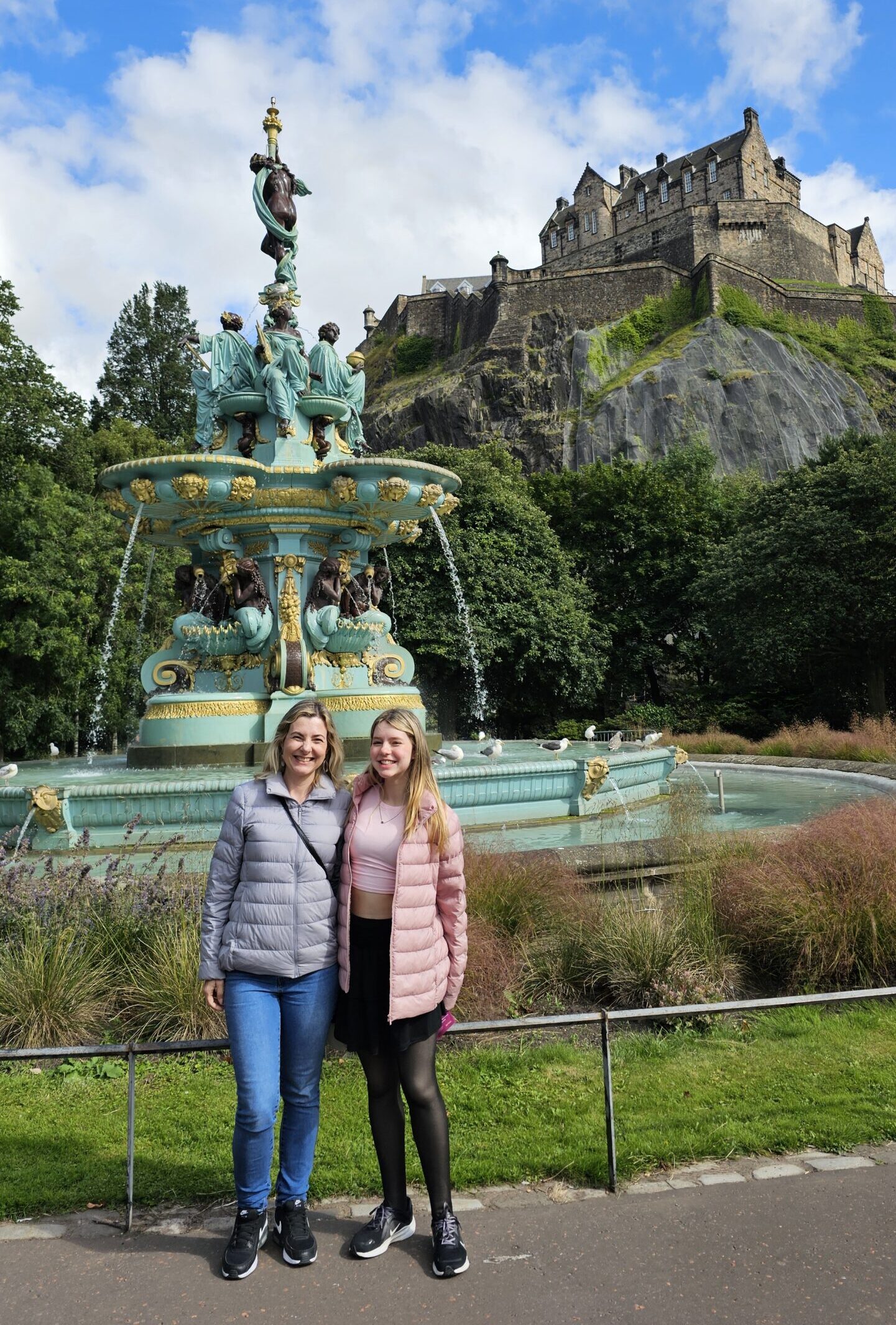 Ross Fountain, fonte vitoriana em ferro fundido, nos Princes Street Gardens com o Castelo de Edimburgo iluminado ao fundo.