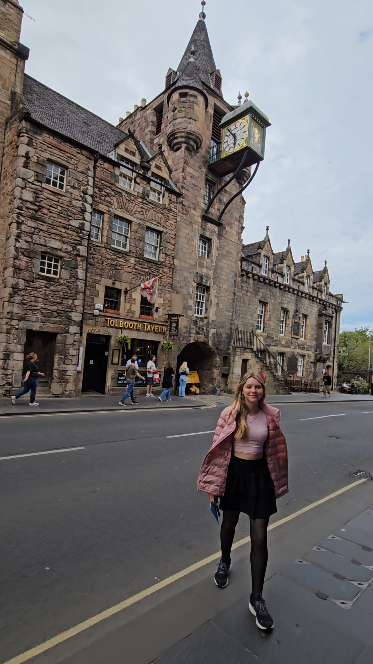 Fachada histórica do Tolbooth Tavern na Royal Mile de Edimburgo, com torre de relógio e arquitetura medieval do século XVI.